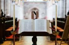 Religionspolitik heute - Ausblick von einer Kanzel auf eine aufgeschlagene Bibel und den leeren Kirchinnenraum.