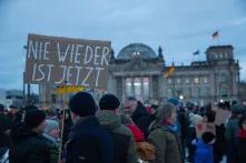 Eine Menschenmenge vor dem Reichstag in Berlin, auf einem Pappschild steht "Nie wieder ist jetzt"