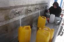 GAZA, (Xinhua) - Palästinenserin füllt Flaschen und Behälter mit Trinkwasser 