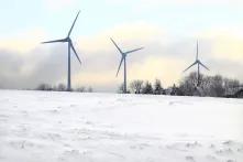 Windräder auf schneebedeckter Wiese