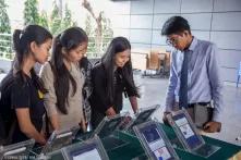 Four girls looking at tablets to test the App "Khmer Rouge History"