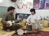 Rahim Gul, holding the rabab (lute), is helping Ajmal Khan, an Afghan singer, to improve his skills at the tabla during routine practice at a music academy. Pakistani musicians have extended full cooperation to fleeing Afghan artistes by providing them sh
