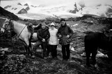 Ein schwarz-weißes Bild Yvon Chouinard, Chris Tompkins und Doug Tompkins zusammen in den Bergen. Es gibt zwei Pferde neben der Kleingruppe