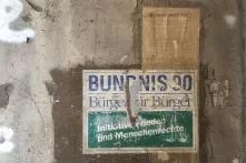 Auf einer grauen Betonwand klebt ein altes, zerschlissenes Wahlplakat, darauf steht: "Bündnis 90 Bürger für Bürger Initiative Frieden und Menschenrechte