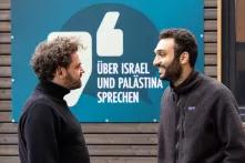 Shai Hoffmann und Ahmad Dakhnous stehen vor Eingan des Safe Place. Auf einem blauen Schild steht "Über Israel und Palästina sprechen"