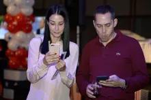 Gäste auf der Wahlparty der US-Botschaft in Israel schauen auf ihre Handys