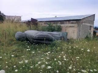 Eine Stalin-Statue liegt mit dem Gesicht nach unten auf einer Wiese